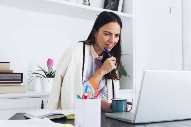 Modern woman using laptop working on latino business