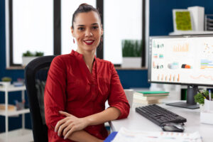 Portrait of business woman in corporate office sitting at desk making a business tax planning